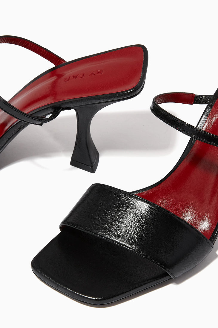 Black leather square toe mules with ankle strap and flared kitten heel featuring red sole — By Far | Endless UAE