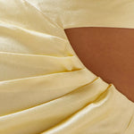 Pale yellow gathered maxi dress fabric detail showing silky texture and draping with skin visible through gathered sections — Shona Joy | Endless UAE