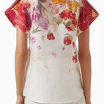 Woman wearing floral print blouse and wide-leg pants with brown handbag — Leo Lin | Endless UAE