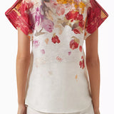 Woman wearing floral print blouse and wide-leg pants with brown handbag — Leo Lin | Endless UAE