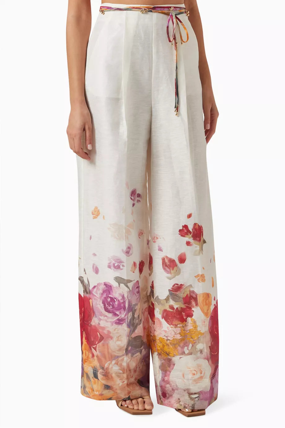 Woman wearing floral print blouse and wide-leg pants with brown handbag — Leo Lin | Endless UAE