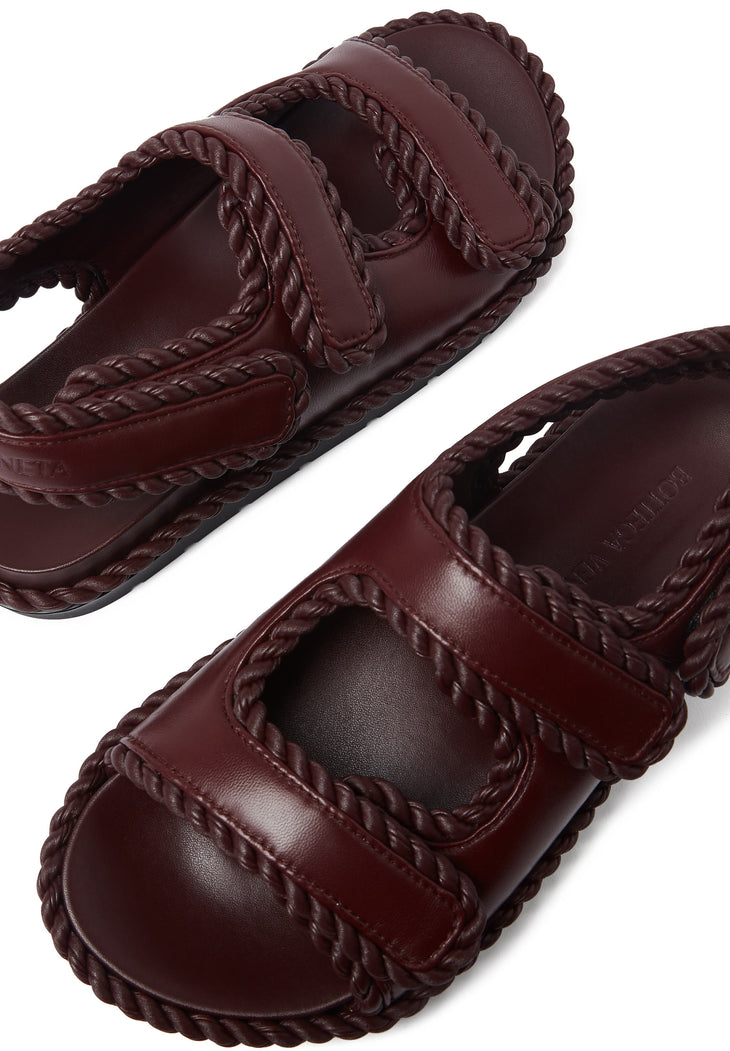 Deep burgundy leather flat sandals with braided trim detailing and double straps — Bottega Veneta | Endless UAE