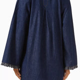 Dark denim mini dress with long sleeves, fringe trim detail at cuffs and hem, relaxed fit silhouette, back view — Zimmermann | Endless UAE