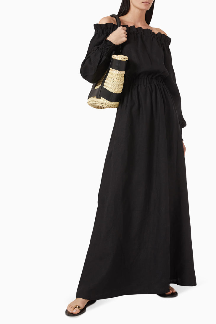 Black off-shoulder linen maxi dress with ruched neckline and billowy sleeves, styled with woven basket bag and sandals — Moeva | Endless UAE