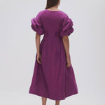 Woman wearing Adelie Puff Sleeve Midi Dress in plum with black strappy sandals — Aje | Endless UAE
