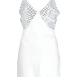 White slip dress with studded chest panel worn with yellow clutch and black sandals — De La Vali | Endless UAE