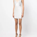 White slip dress with studded chest panel worn with yellow clutch and black sandals — De La Vali | Endless UAE