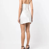 White slip dress with studded chest panel worn with yellow clutch and black sandals — De La Vali | Endless UAE