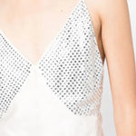 White slip dress with studded chest panel worn with yellow clutch and black sandals — De La Vali | Endless UAE