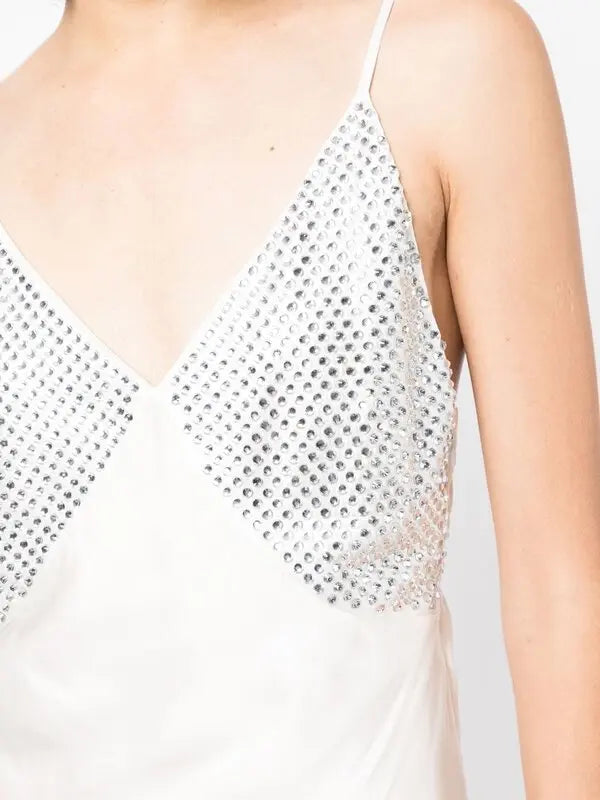 White slip dress with studded chest panel worn with yellow clutch and black sandals — De La Vali | Endless UAE