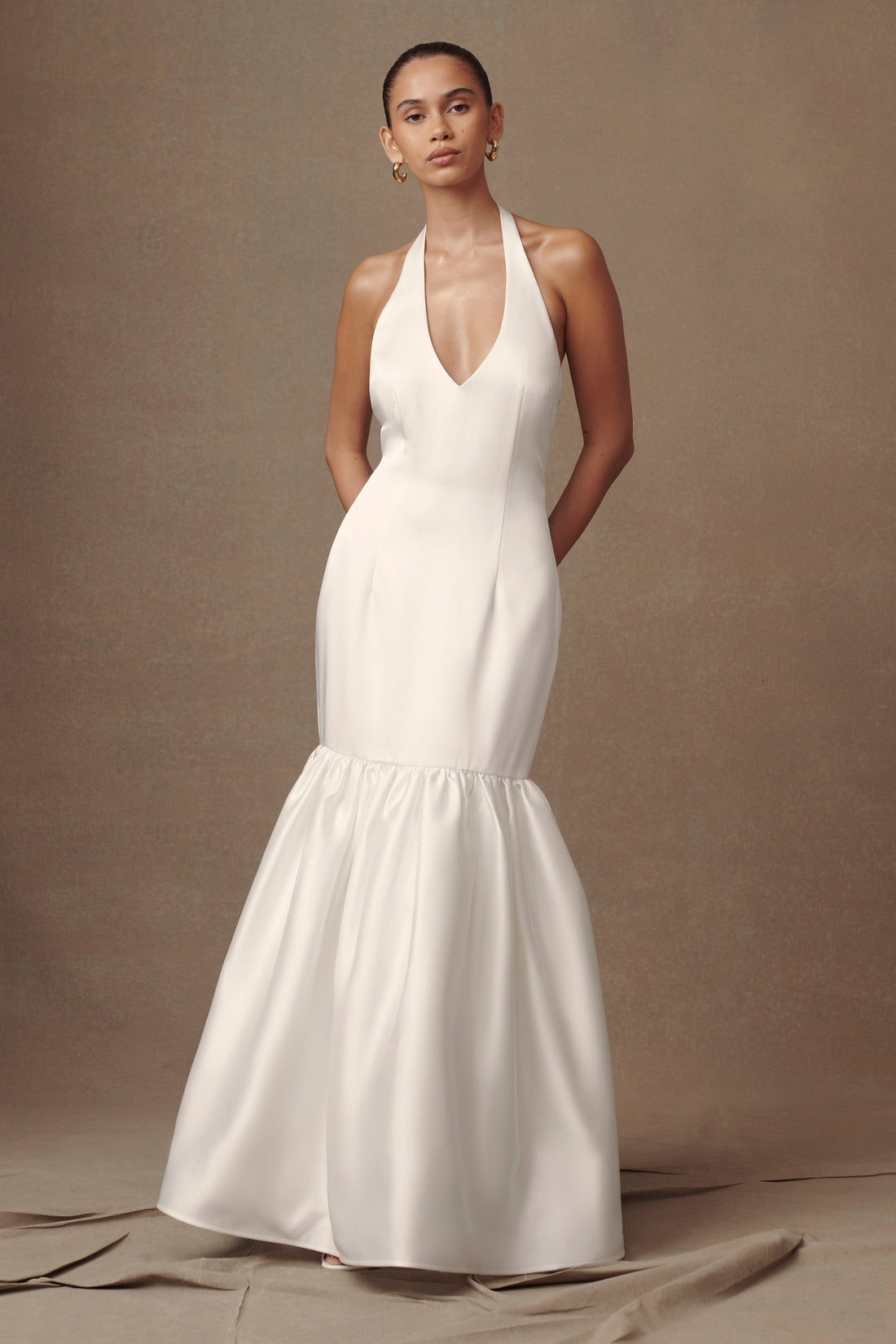Elegant white satin halter gown with plunging V-neck and mermaid silhouette with gathered tiered skirt — Meshki | Endless UAE