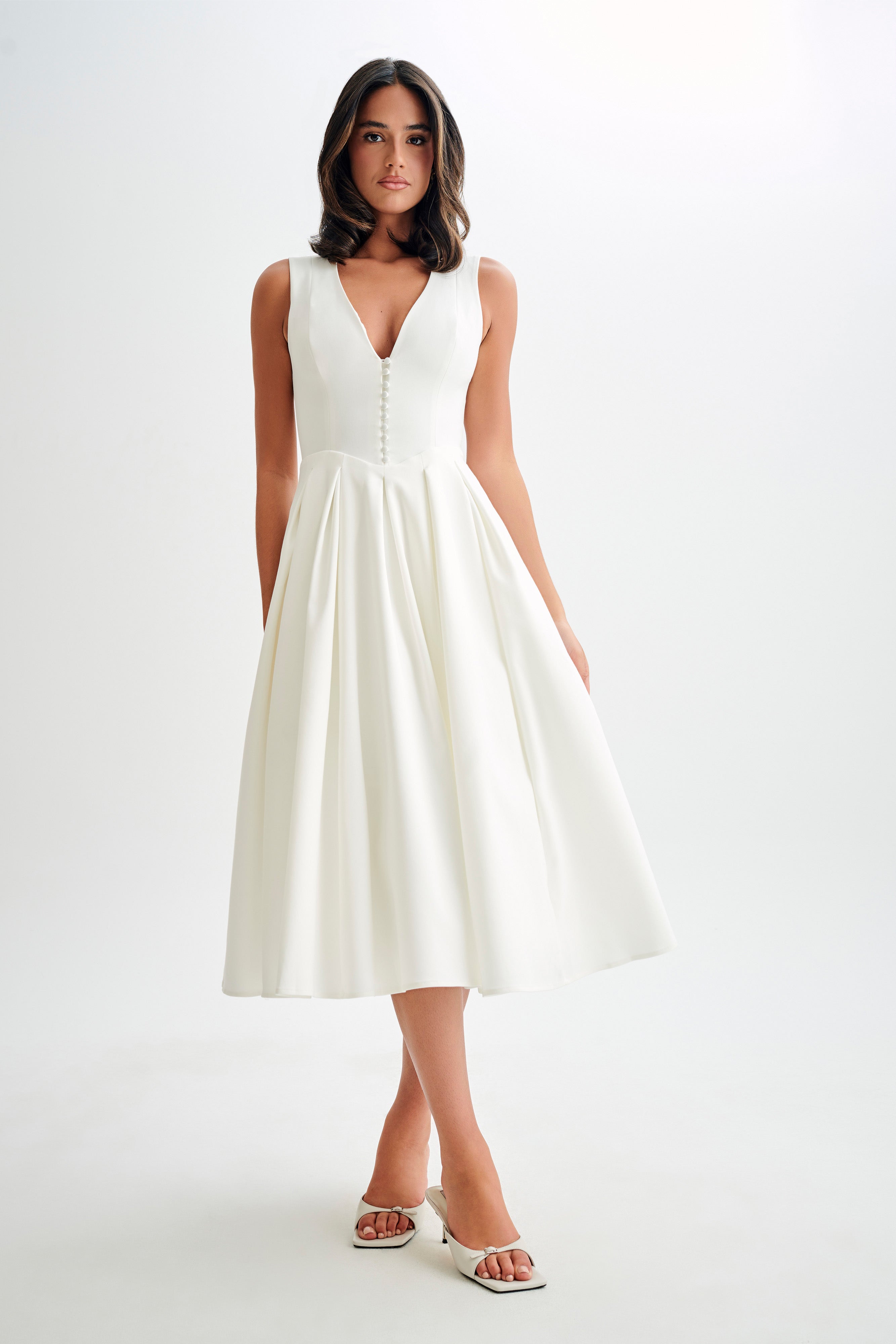 Woman wearing cream sleeveless midi dress with button front — Meshki | Endless UAE