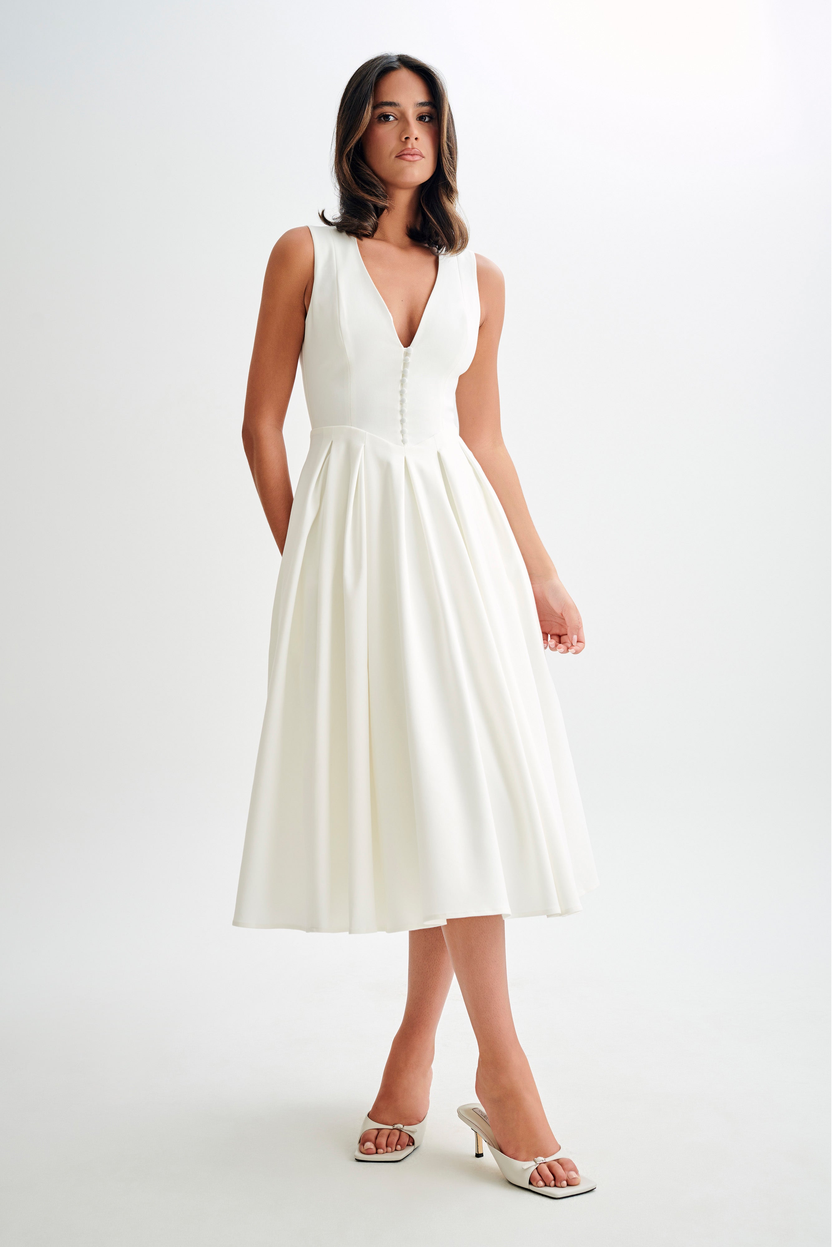 Woman wearing cream sleeveless midi dress with button front — Meshki | Endless UAE