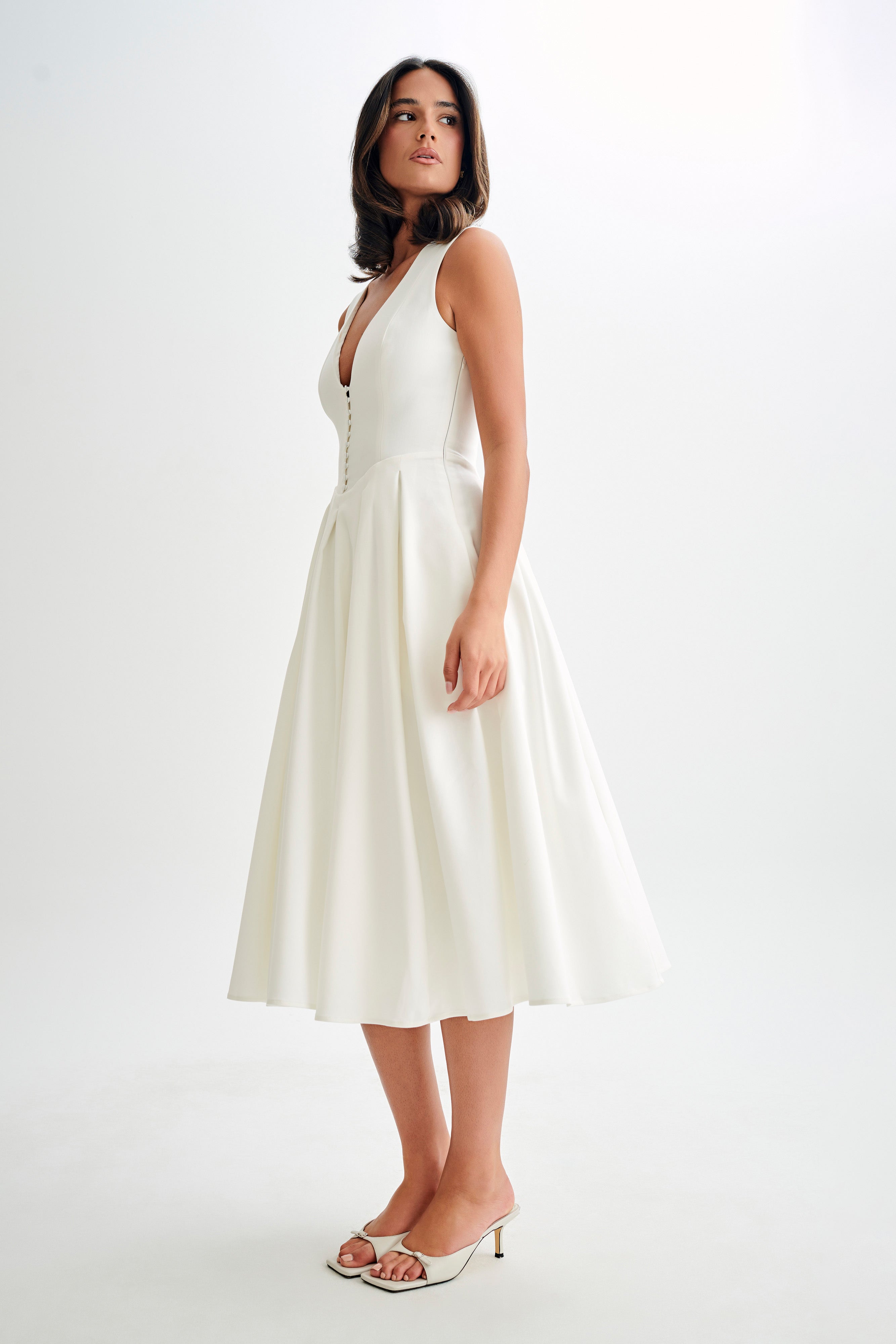Woman wearing cream sleeveless midi dress with button front — Meshki | Endless UAE