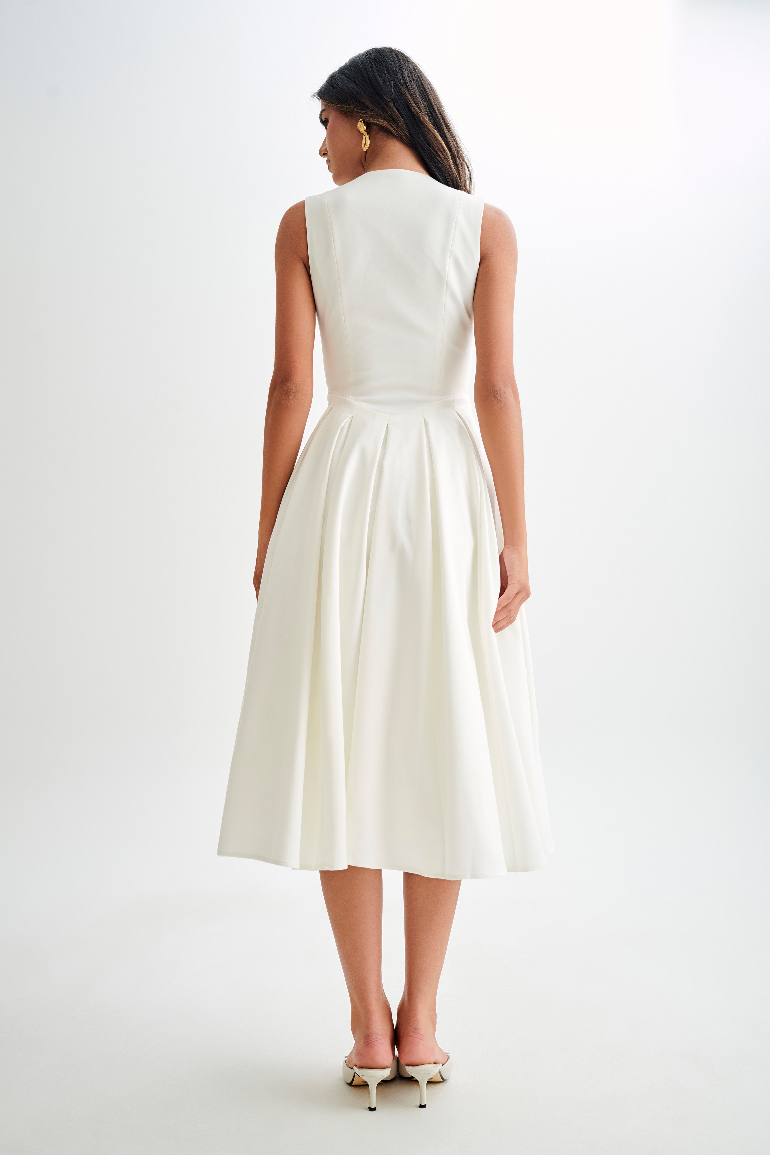 Woman wearing cream sleeveless midi dress with button front — Meshki | Endless UAE