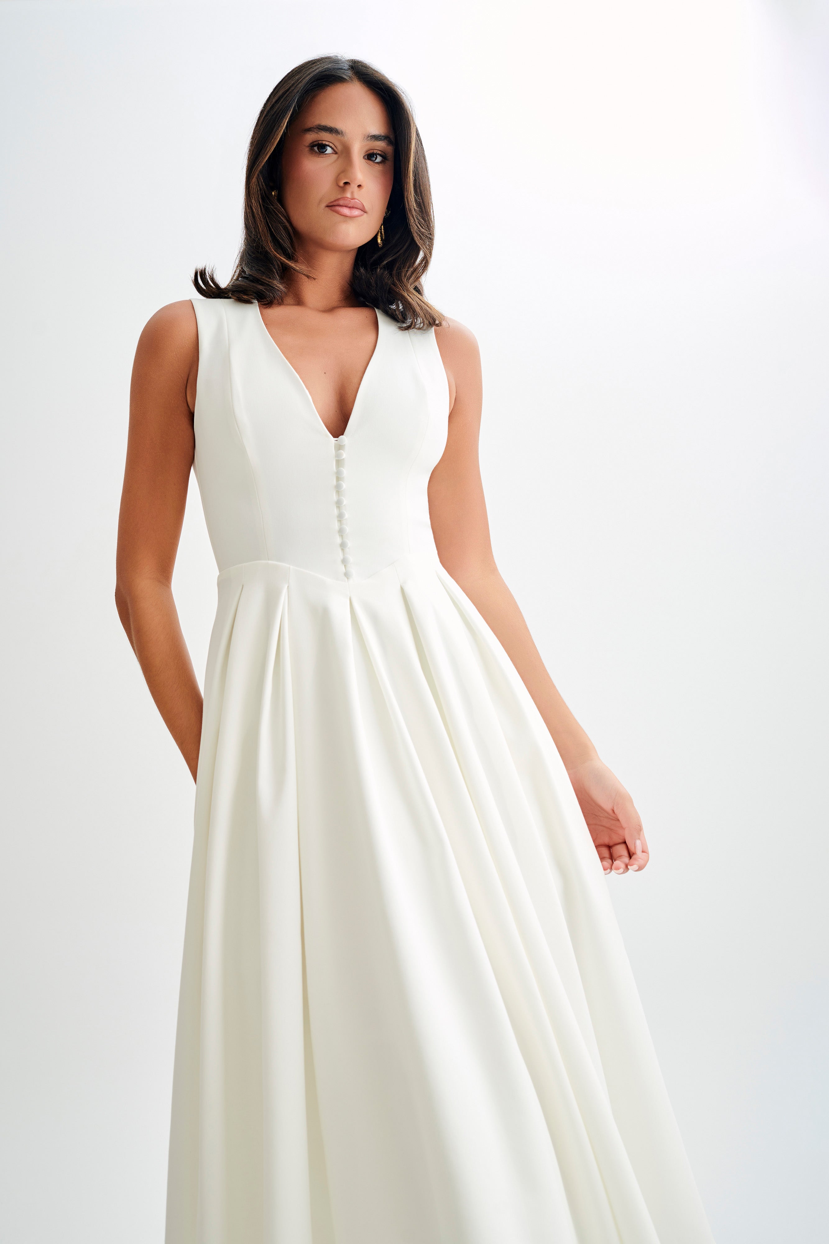 Woman wearing cream sleeveless midi dress with button front — Meshki | Endless UAE