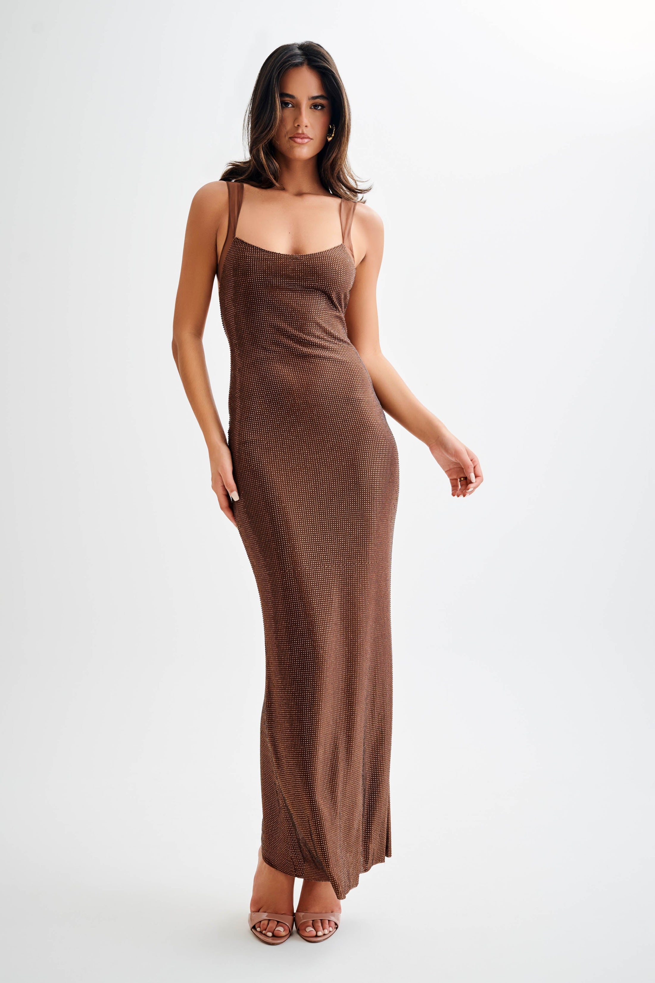 Jasmyn Hot Fix Maxi Dress With Mesh Back in bronze worn by woman against beach backdrop — Meshki | Endless UAE