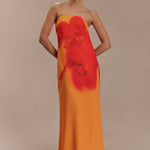 Woman wearing a strapless orange and red ombre chiffon maxi dress with gold hoop earrings — Meshki | Endless UAE