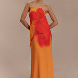 Woman wearing a strapless orange and red ombre chiffon maxi dress with gold hoop earrings — Meshki | Endless UAE