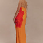 Woman wearing a strapless orange and red ombre chiffon maxi dress with gold hoop earrings — Meshki | Endless UAE