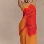 Woman wearing a strapless orange and red ombre chiffon maxi dress with gold hoop earrings — Meshki | Endless UAE