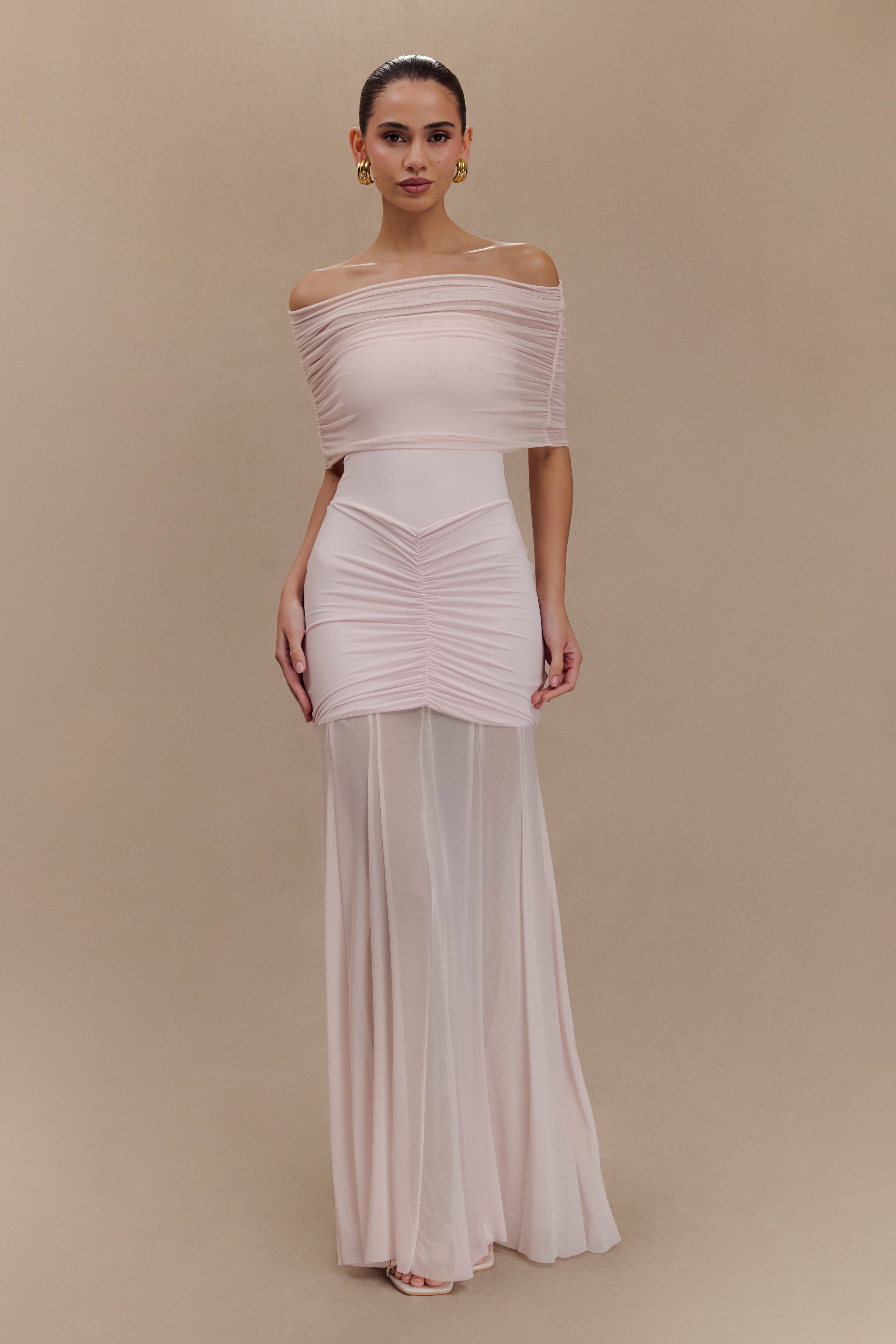 Woman wearing blush off-shoulder maxi dress with ruched details and mesh panel — Meshki | Endless UAE