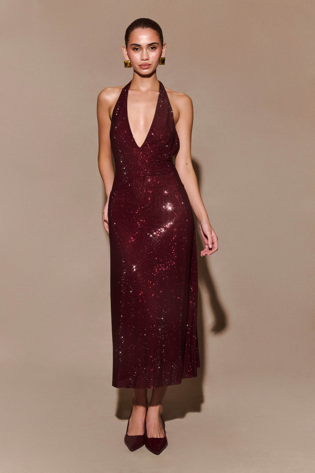 Burgundy sequined halter midi dress with plunging V-neckline and backless design paired with matching heels — Meshki | Endless UAE