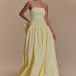 Elegant strapless maxi dress in soft yellow with fitted bodice, gathered drop-waist skirt, and detachable bow detail — Meshki | Endless UAE