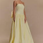 Elegant pale yellow strapless maxi dress with fitted bodice, gathered waist, flowing A-line skirt and detachable bow accent — Meshki | Endless UAE