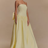 Elegant pale yellow strapless maxi dress with fitted bodice, gathered waist, flowing A-line skirt and detachable bow accent — Meshki | Endless UAE