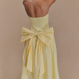 Elegant pale yellow strapless maxi dress featuring a dramatic oversized bow detail at the back waist — Meshki | Endless UAE