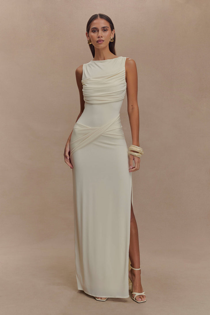 Elegant sleeveless cream maxi dress with ruched bodice draping and high leg slit, styled with gold accessories — Meshki | Endless UAE