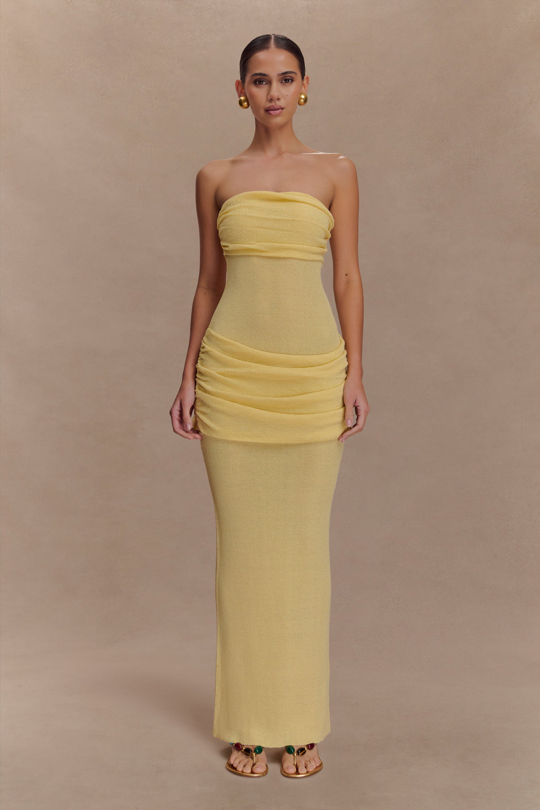 Elora Strapless Knit Maxi Dress in yellow featuring ruched bodice and hip details, worn with gold earrings — Meshki | Endless UAE