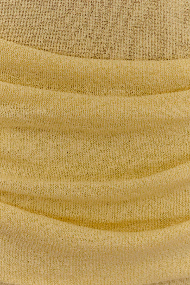 Mustard yellow ribbed knit fabric with soft folds showing texture and drape of strapless maxi dress — Meshki | Endless UAE