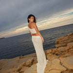 Ivory sequin crop top and maxi skirt set on model by rocky coastline at sunset — Label Loft London | Endless UAE