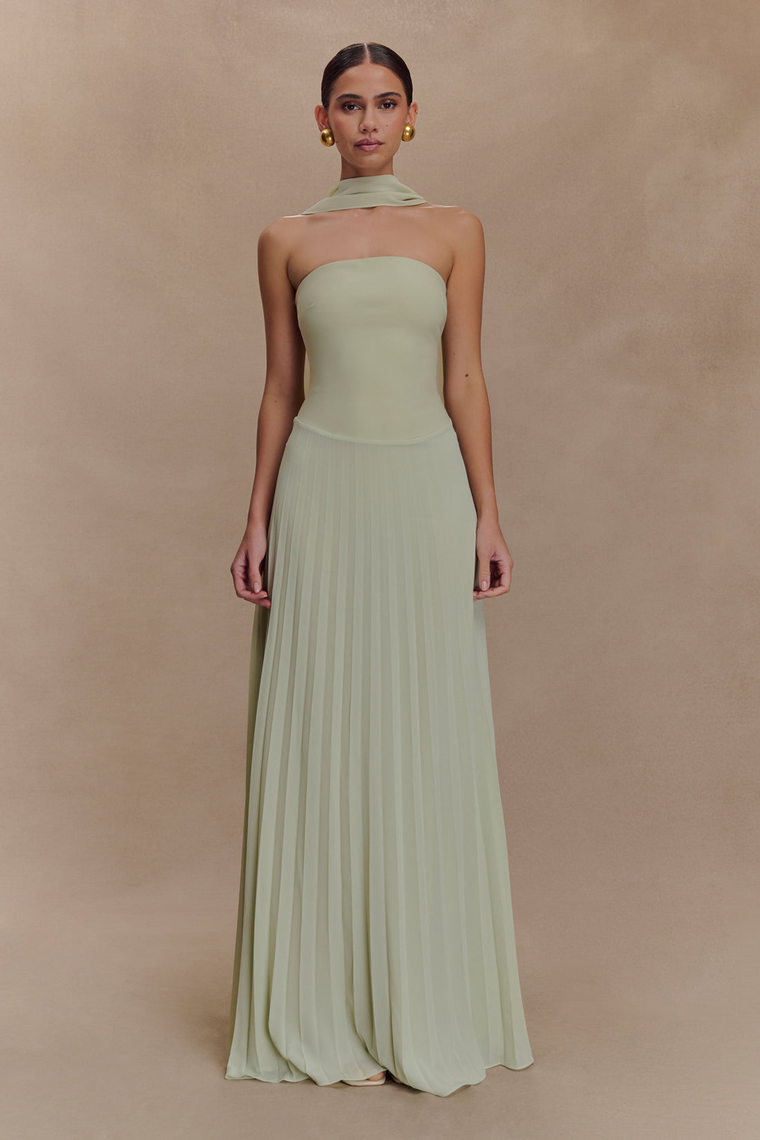 Woman wearing pale sage strapless maxi dress with pleated skirt and matching neck scarf — Meshki | Endless UAE