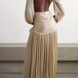 Gold pleated cutout maxi dress with twisted knot detail and long sleeves on model with woven clutch — Patbo | Endless UAE