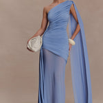 Woman wearing periwinkle blue one shoulder maxi dress with draped fabric detail and cream clutch — Meshki | Endless UAE