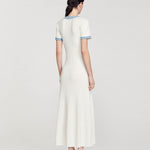 Rear view of woman wearing white ribbed knit maxi dress with denim trim detail and short sleeves — Sandro | Endless UAE