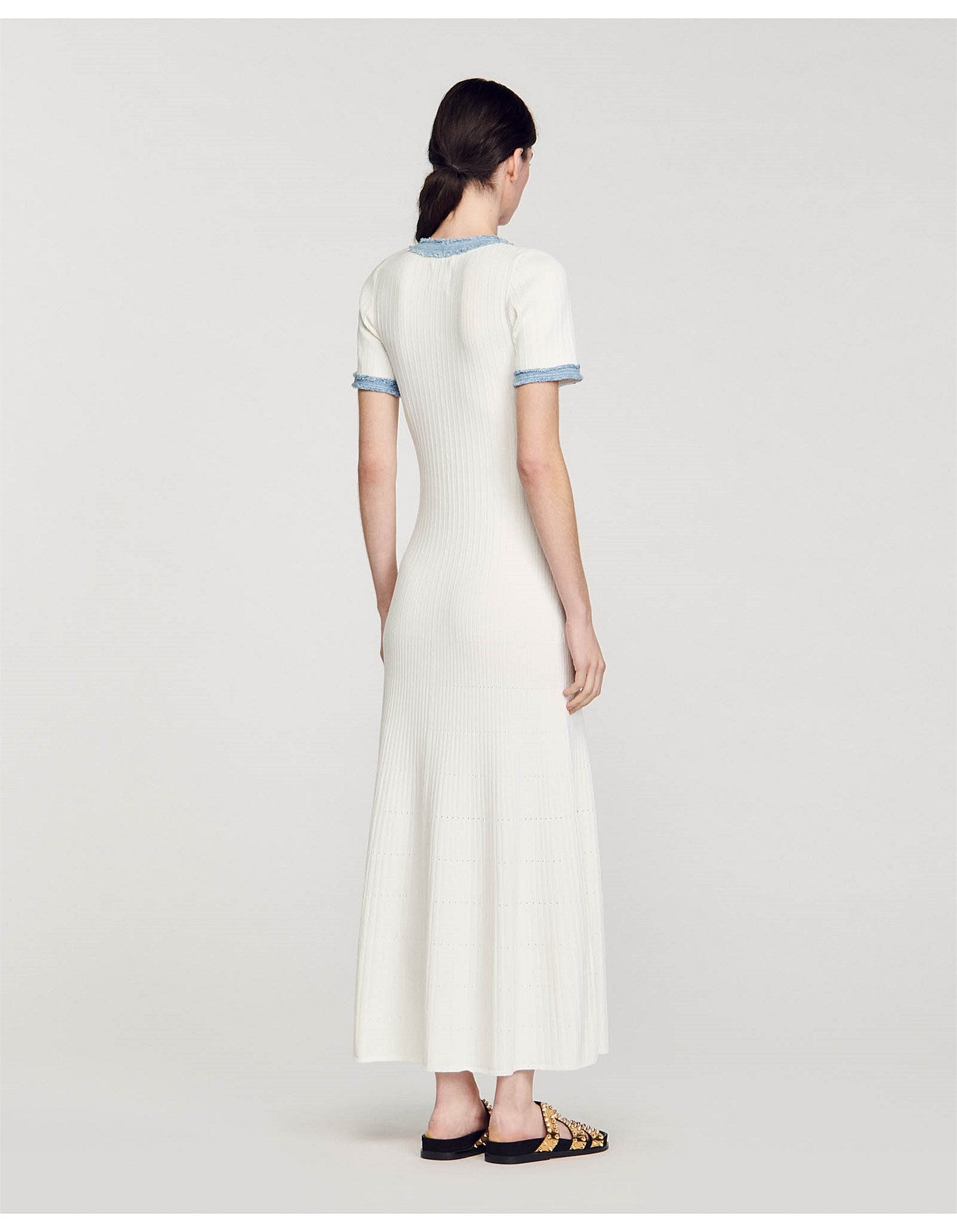 Rear view of woman wearing white ribbed knit maxi dress with denim trim detail and short sleeves — Sandro | Endless UAE