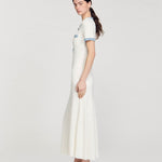 Long white knitted dress with blue contrast trim on short sleeves, worn with gold embellished sandals — Sandro | Endless UAE