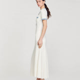 Long white knitted dress with blue contrast trim on short sleeves, worn with gold embellished sandals — Sandro | Endless UAE