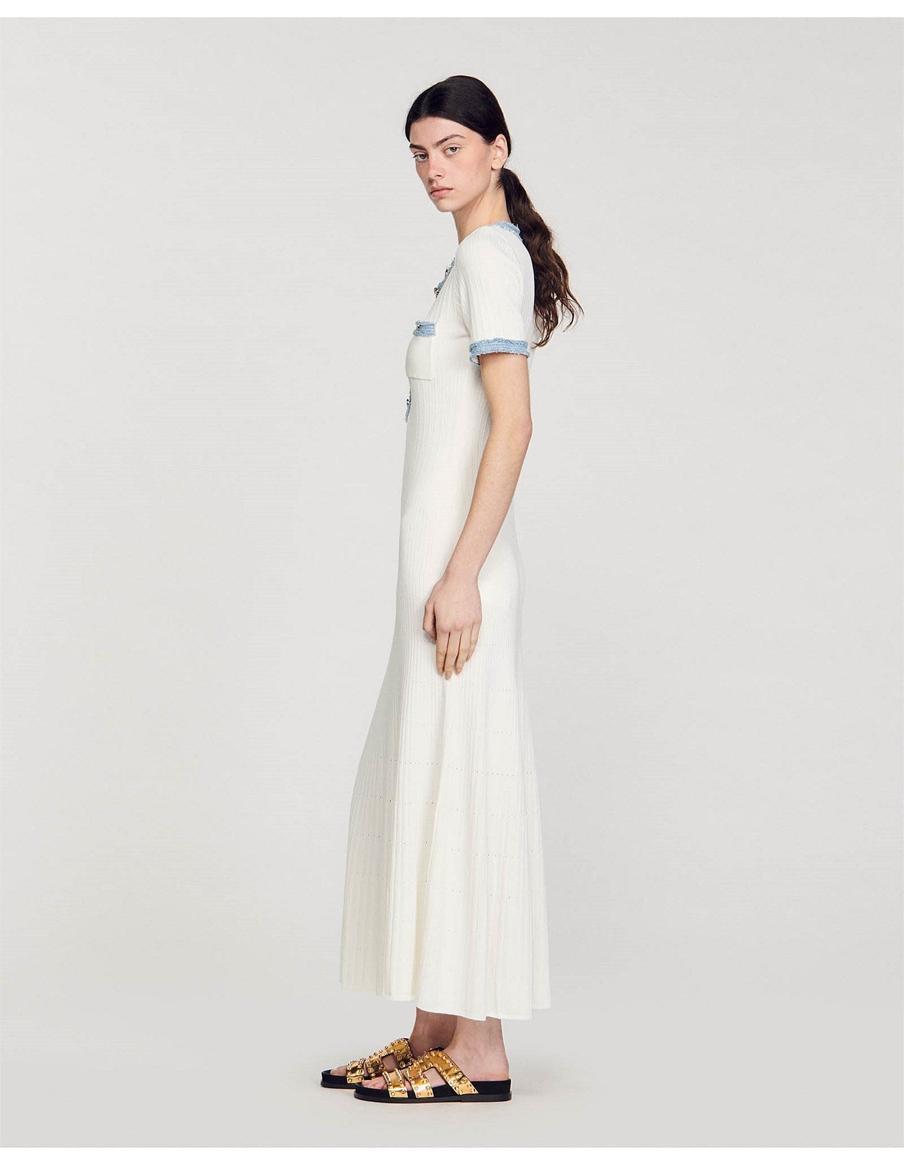 Long white knitted dress with blue contrast trim on short sleeves, worn with gold embellished sandals — Sandro | Endless UAE