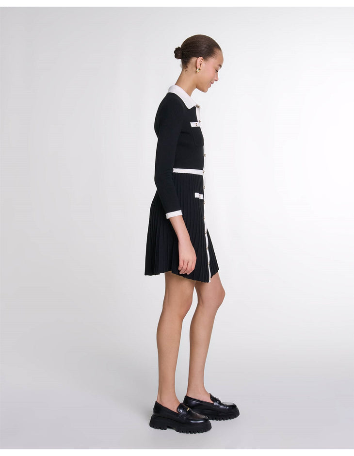 Black pleated knit dress with white contrast collar and cuffs, side view on model — Maje | Endless UAE