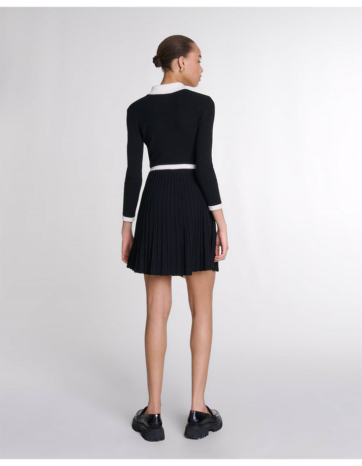 Black knit dress with white collar and cuff trim, pleated skirt, worn with black chunky loafers — Maje | Endless UAE