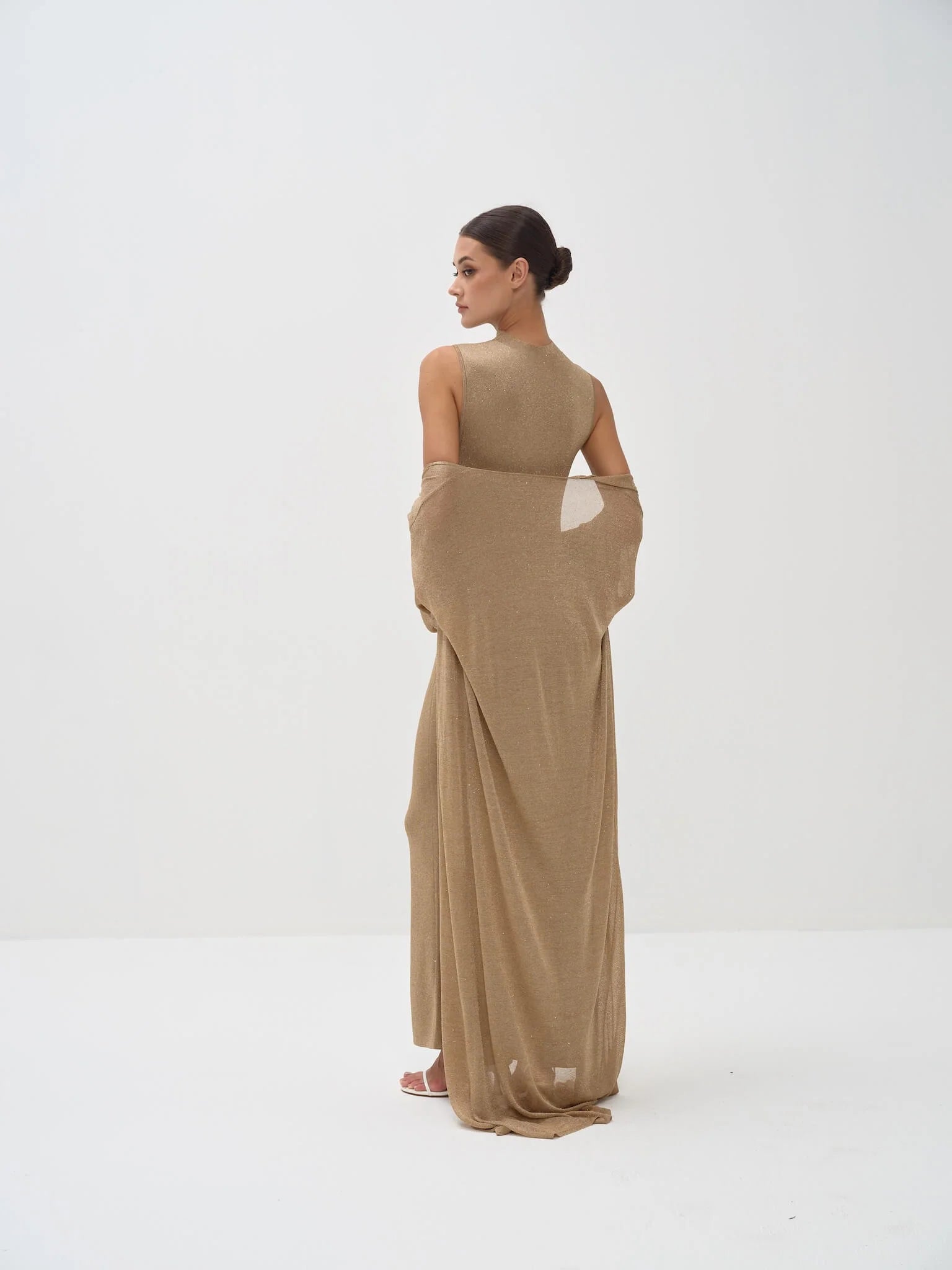 Elegant beige sleeveless bodysuit with matching draped shawl wrap, model shown from behind in minimalist setting — Nora The Label | Endless UAE