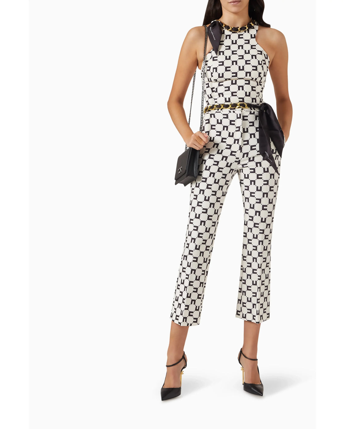 Woman wearing geometric patterned crop top and pants with black accessories — Elisabetta Franchi | Endless UAE