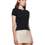 Woman wearing black and white contrast t-shirt with cream skirt — Courrèges | Endless UAE