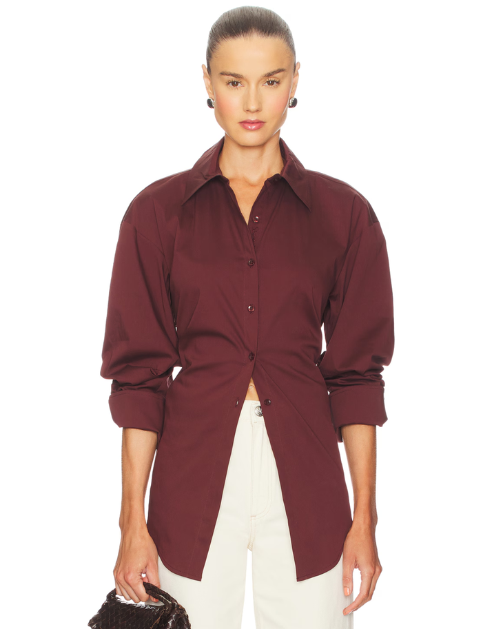 Burgundy poplin button-up shirt styled with cream trousers and black bag — Simon Miller | Endless UAE