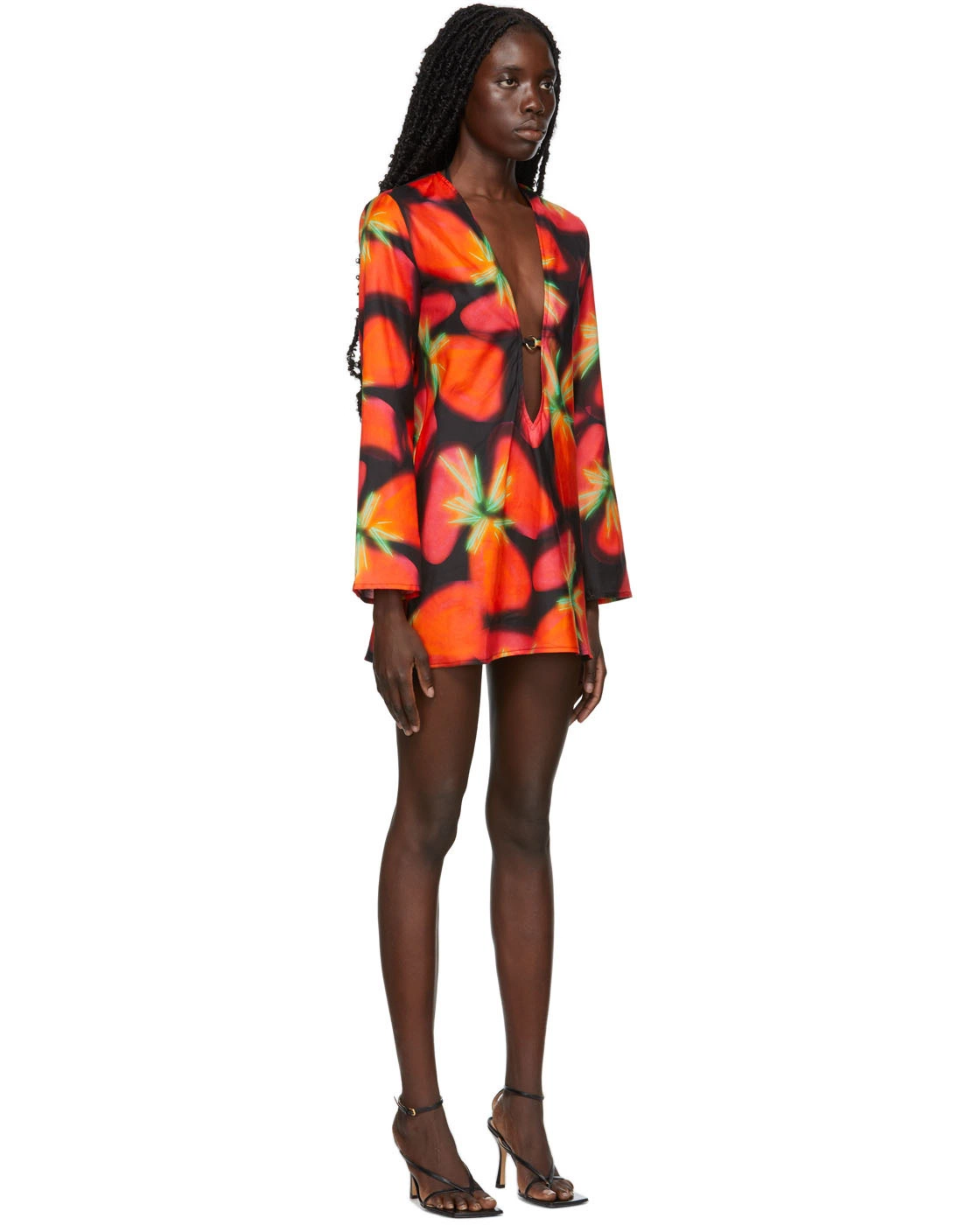 Woman wearing vibrant red and orange strawberry print blazer dress with green handbag — Louisa Ballou | Endless UAE